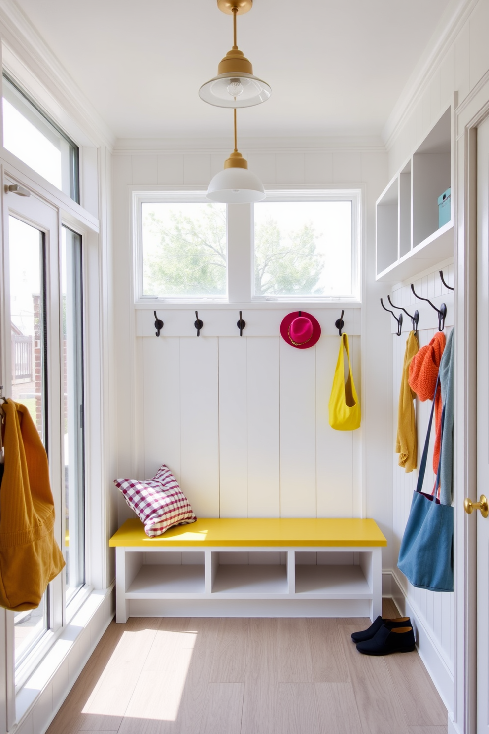 A bright and airy mudroom features large windows that allow natural light to flood the space. The walls are painted in a soft white hue, complemented by light wood accents and a cheerful yellow bench. The lighting fixtures are modern and minimalist, hanging elegantly from the ceiling to illuminate the room. Decorative hooks line the walls, adorned with colorful bags and hats, adding a playful touch to the functional space.