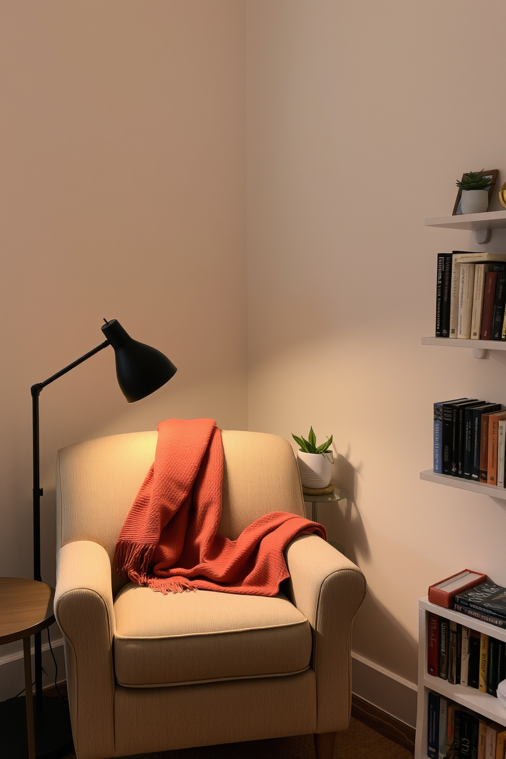 A cozy reading nook with a plush armchair upholstered in soft fabric and a small side table beside it. A warm throw blanket is draped over the armchair, and a floor lamp casts a gentle light over the space. The walls are painted in a light pastel color, creating a serene atmosphere. A collection of books is neatly arranged on a nearby shelf, and a small potted plant adds a touch of greenery to the corner.